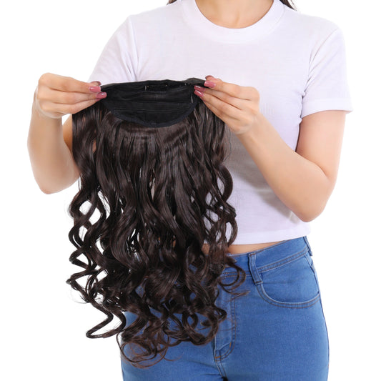 Woman holding a set of wavy hair extensions against a white background