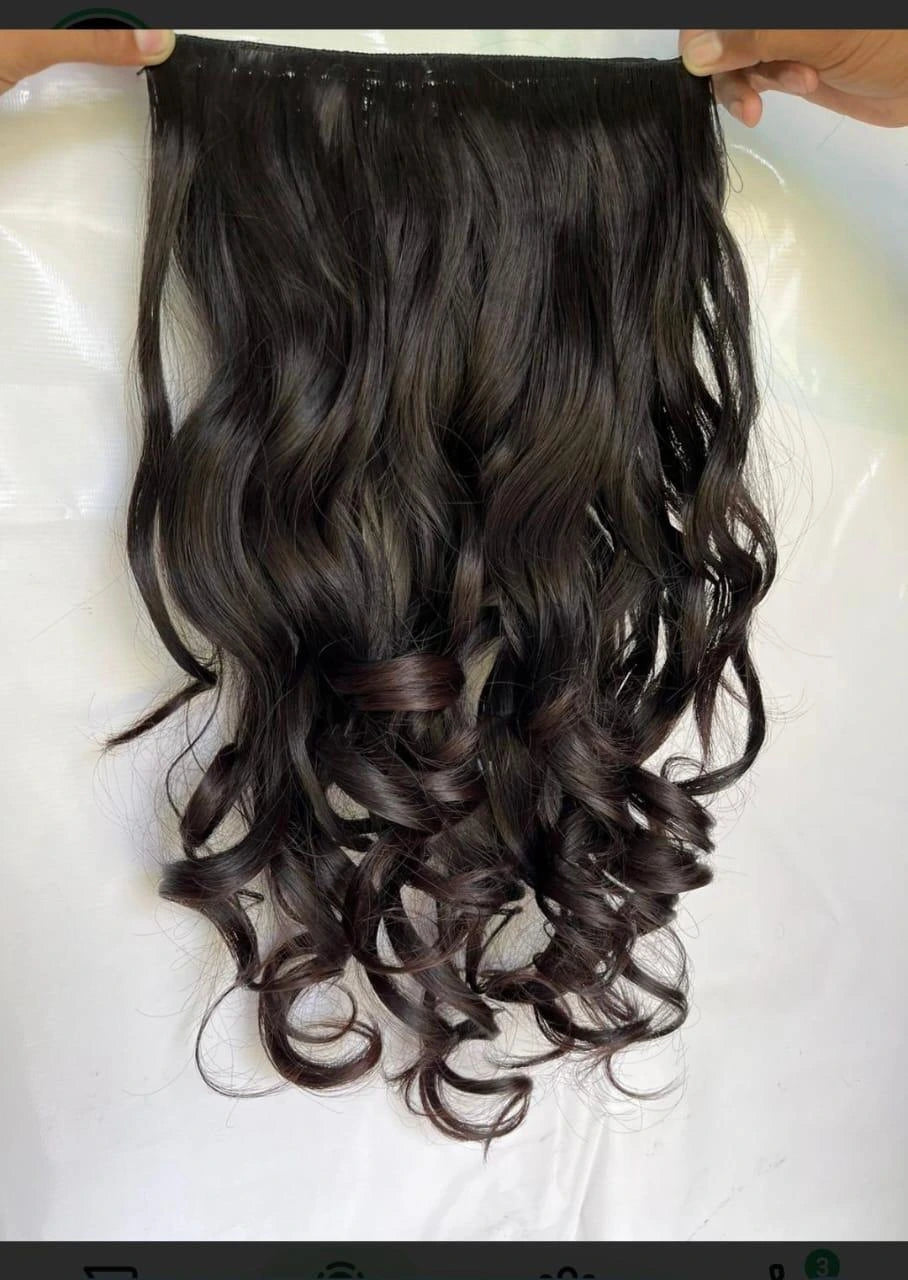 Curly hair extension held by hands on a white background